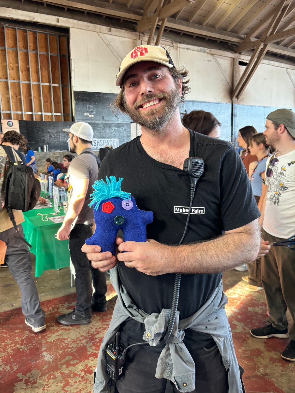A Maker Faire participant proudly holding a blue handmade doll